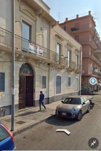 a small car parked in front of a building at EUREKA APArtment in Catania