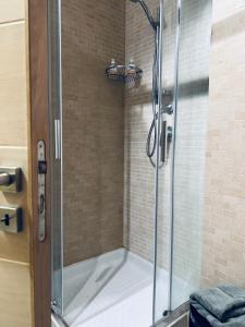 a shower with a glass shower stall in a bathroom at EUREKA APArtment in Catania