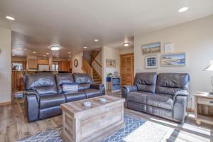 a living room with two leather couches and a coffee table at Seas the Day in Shorepine in Pacific City