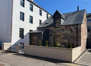 a large brick building with a large white building at Balnain Street Cottage in Inverness