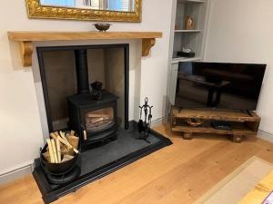 a living room with a fireplace and a wooden floor at Balnain Street Cottage in Inverness