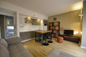 Una cocina y una sala de estar con una mesa y un sofá. en T2, Centre ville, Gare 600m, Prox Lille, Terrasse, en Tourcoing