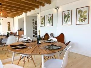 a dining room with a wooden table and chairs at PalmBreeze in Vilanova i la Geltrú