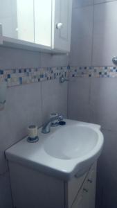 a white sink in a bathroom with a cup at Departamento Lo de Juli in Ramallo