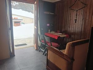 a dining room with a table and chairs and a sliding glass door at Fiocco di sole Apartment in Sestriere +12 photos