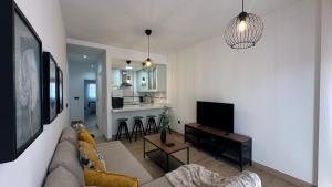 a living room with a couch and a tv and a kitchen at La casa de Chloe in Torrenueva