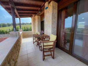 a patio with a wooden table and chairs on a balcony at Artis Stone Heaven Retreat in Kalandra
