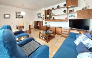 a living room with a blue couch and a television at Stunning Apartment In Oropesa Del Mar in Oropesa del Mar