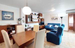 a living room with a table and a blue couch at Stunning Apartment In Oropesa Del Mar in Oropesa del Mar