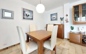 a dining room with a wooden table and white chairs at Stunning Apartment In Oropesa Del Mar in Oropesa del Mar