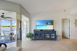a living room with a flat screen tv on a wall at 2nd floor bayfront Siesta Key condo with private beach access in Siesta Key