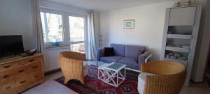 a living room with a couch and chairs and a tv at Appartements an der Kaiserpfalz - Königshof in Forchheim
