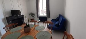 a dining room with a wooden table and a blue chair at Le Flobart jardin partagé in Berck-sur-Mer