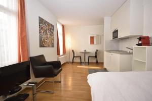 a room with a bed and a table and chairs at Cute studio in the city center - Stork 23 in Zürich