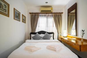 a bedroom with a bed with two towels on it at Royal SPA Massarossa Pool Villa Pattaya-23 in Pattaya Central +35 photos