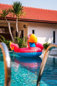 a raft in a swimming pool next to a house at Royal SPA Massarossa Pool Villa Pattaya-23 in Pattaya Central