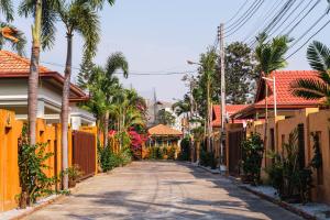 an empty street with houses and palm trees at Royal SPA Massarossa Pool Villa Pattaya-23 in Pattaya Central