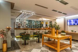 a restaurant with green chairs and a bar at Glow Boutique Hotel & Suites in Sarandë