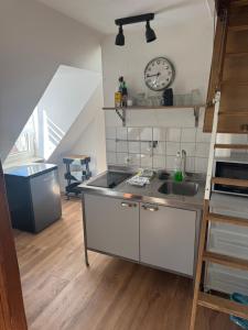 凯撒斯劳滕Monteurapartment in Kaiserslautern的厨房配有水槽和墙上的时钟