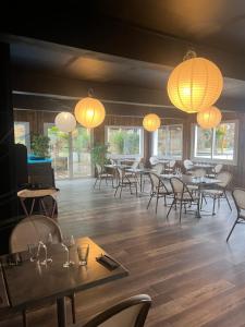 a dining room with tables and chairs and lanterns at The Originals Boutique, Hôtel Lakeside, Biscarrosse , Lac in Parentis-en-Born