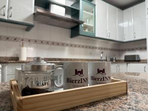 two mugs on a wooden tray on a kitchen counter at BierzINN Apartamentos - Martina in Ponferrada