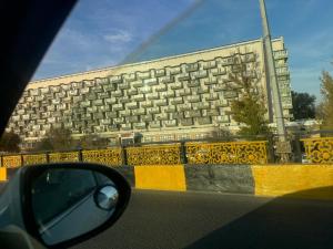 een zijaanzicht spiegel van een auto op een weg met een gebouw bij Ермекова 52 in Karagandy