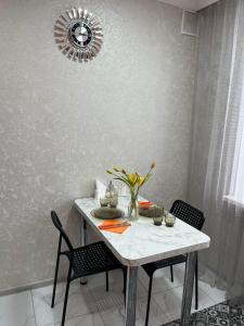 een eettafel met 2 stoelen en een spiegel bij Ермекова 52 in Karagandy +2 foto's