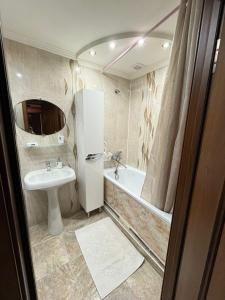 een badkamer met een wastafel, een toilet en een bad bij Ермекова 52 in Karagandy