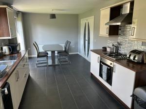 a kitchen with a counter and a table and chairs at Daves Cave in Antrim