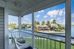 a balcony with two chairs and a view of the water at Bayfront 3BR 2nd floor Siesta Key condo with private beach access in Siesta Key