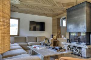 a living room with a couch and a fireplace at Chalet Boucle in Megève