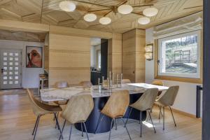 a dining room with a large marble table and chairs at Chalet Boucle in Megève