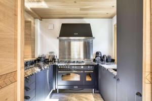 a kitchen with a stove top oven in a kitchen at Chalet Boucle in Megève +33 photos