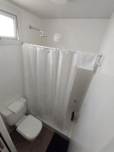a bathroom with a toilet and a shower curtain at RCH Roma in Chacabuco