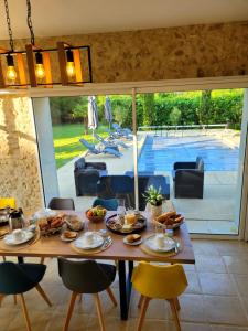 a dining room with a table and a pool at La Maison Tuffeau Bed and Breakfast in Génillé