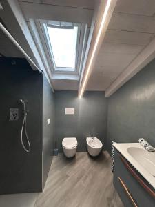 a bathroom with a toilet and a sink and a skylight at VILLA SABRINA VICINA al MARE in Terracina