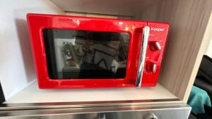 a red microwave sitting on top of a shelf at VILLA SABRINA VICINA al MARE in Terracina