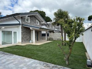 a house with a palm tree in the yard at VILLA SABRINA VICINA al MARE in Terracina