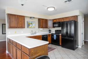 a kitchen with wooden cabinets and a black refrigerator at King Beds Game Room On 290 Large Estate Kitchen in Fredericksburg