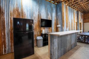 a kitchen with a black refrigerator and a table at King Beds Game Room On 290 Large Estate Kitchen in Fredericksburg +30 photos