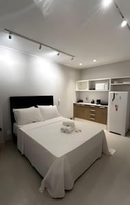 a white bedroom with a large bed and a refrigerator at Conforto e Praticidade - Centro do RJ in Rio de Janeiro +23 photos