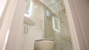 a bathroom with a toilet and a glass shower at Prestige Stays Cardiff Modern 1-Bed Apartment near City Centre Wi-Fi & Lockbox Check-In in Cardiff