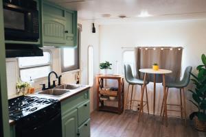 a kitchen with green cabinets and a sink and a table at Sunrise Serenity RV - Panoramic Views in Culebra