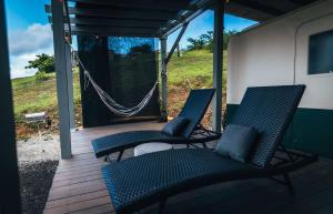 two chairs on a porch with a hammock at Scenic Serene RV - Panoramic Views in Culebra