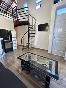 a room with a glass table and a spiral staircase at Two levels Las Terrenas near to beaches in Las Terrenas