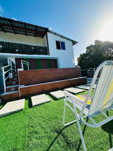 a wooden bench and a chair in front of a house at Two levels Las Terrenas near to beaches in Las Terrenas