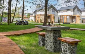 a park with a table and benches in front of a house at Stunning Home In Niechorze With Sauna in Niechorze