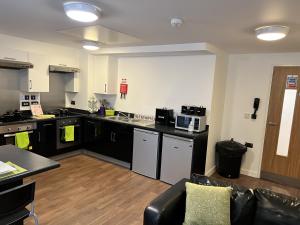 a large kitchen with black counter tops and appliances at Astor House by Pureserviced in Plymouth