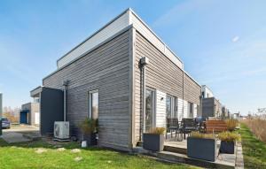 ein kleines Haus mit grauer Außenverkleidung in der Unterkunft Lodge Am Deich in Tossenserdeich