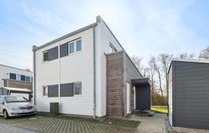 ein weißes Haus mit einem davor geparkten Auto in der Unterkunft Lodge Am Deich in Tossenserdeich + 11 Fotos